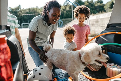 mom and two kids and a dog getting into a car
